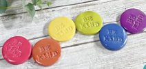 round, colorful tokens made of clay with words stamped on them